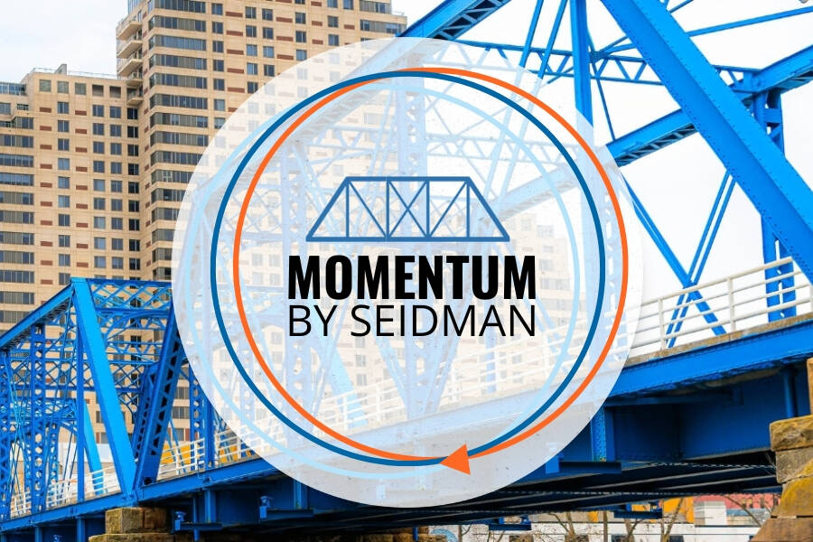 Momentum By Seidman Logo shown over a photo of the blue bridge in Grand Rapids
